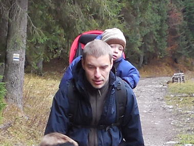 Mężczyzna na szlaku z dzieckiem w nosidełku