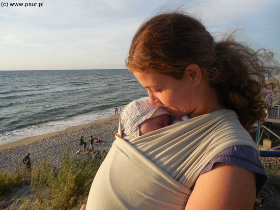 Matka z dzieckiem przytulonym w chuście