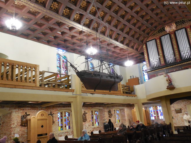 Wnętrze kościoła, w środku nawy podwieszony duży model statku
